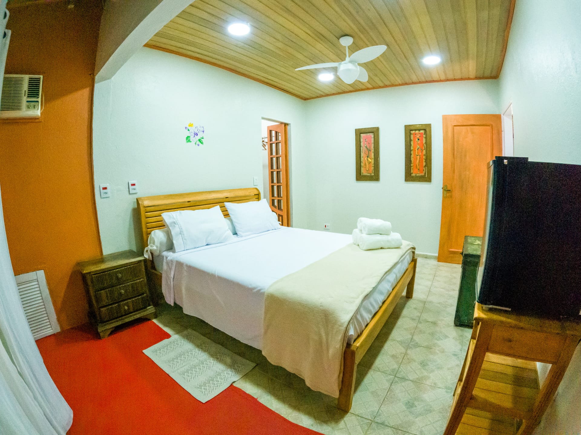 Suite Laranja com teto de madeira e TV